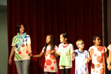 Rosi und einige Kinder stehen auf der Bühne und präsentieren eine einstudierte Show.