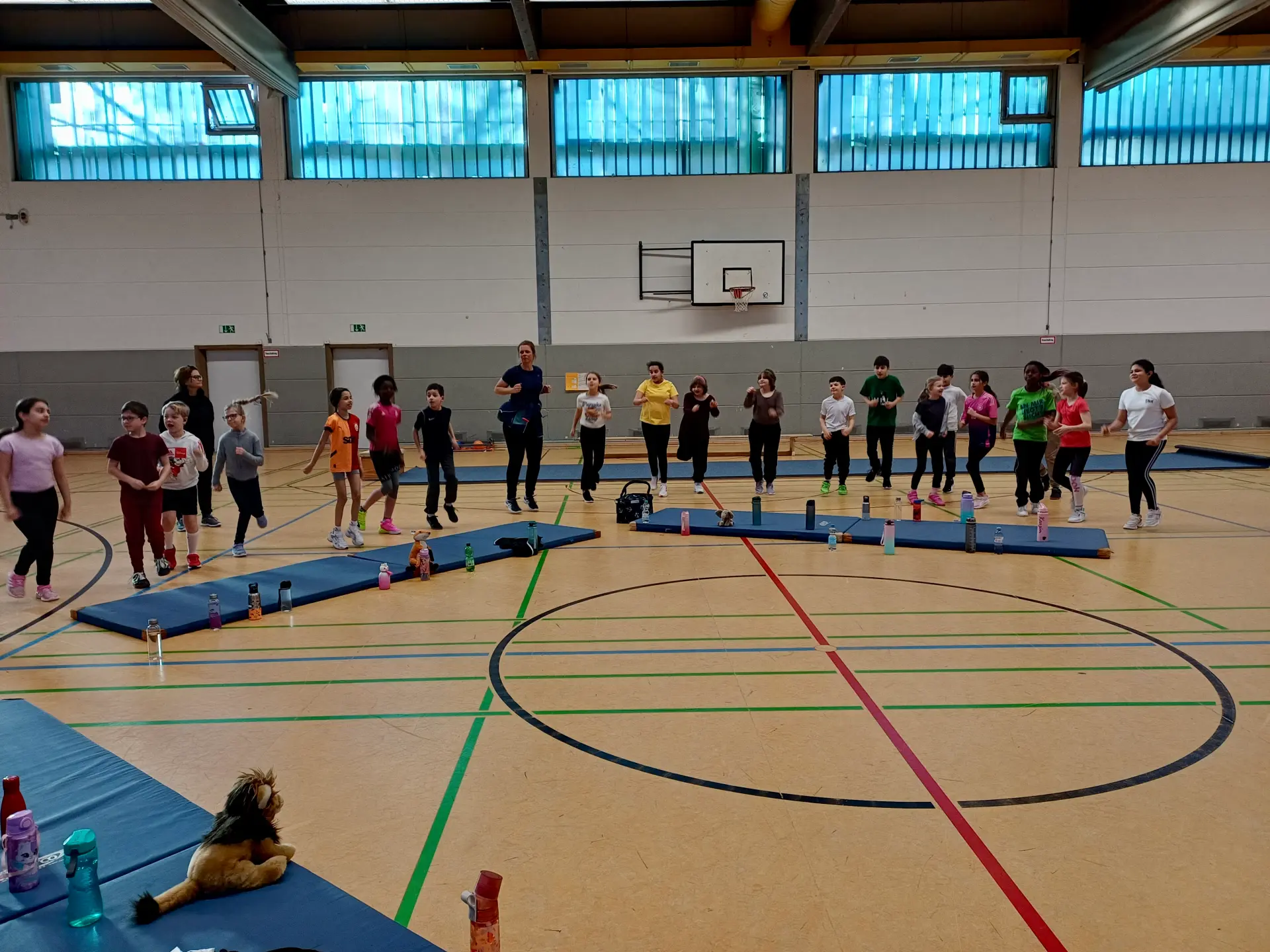 grundschüler in der turnhalle bei einer aufwärmübung