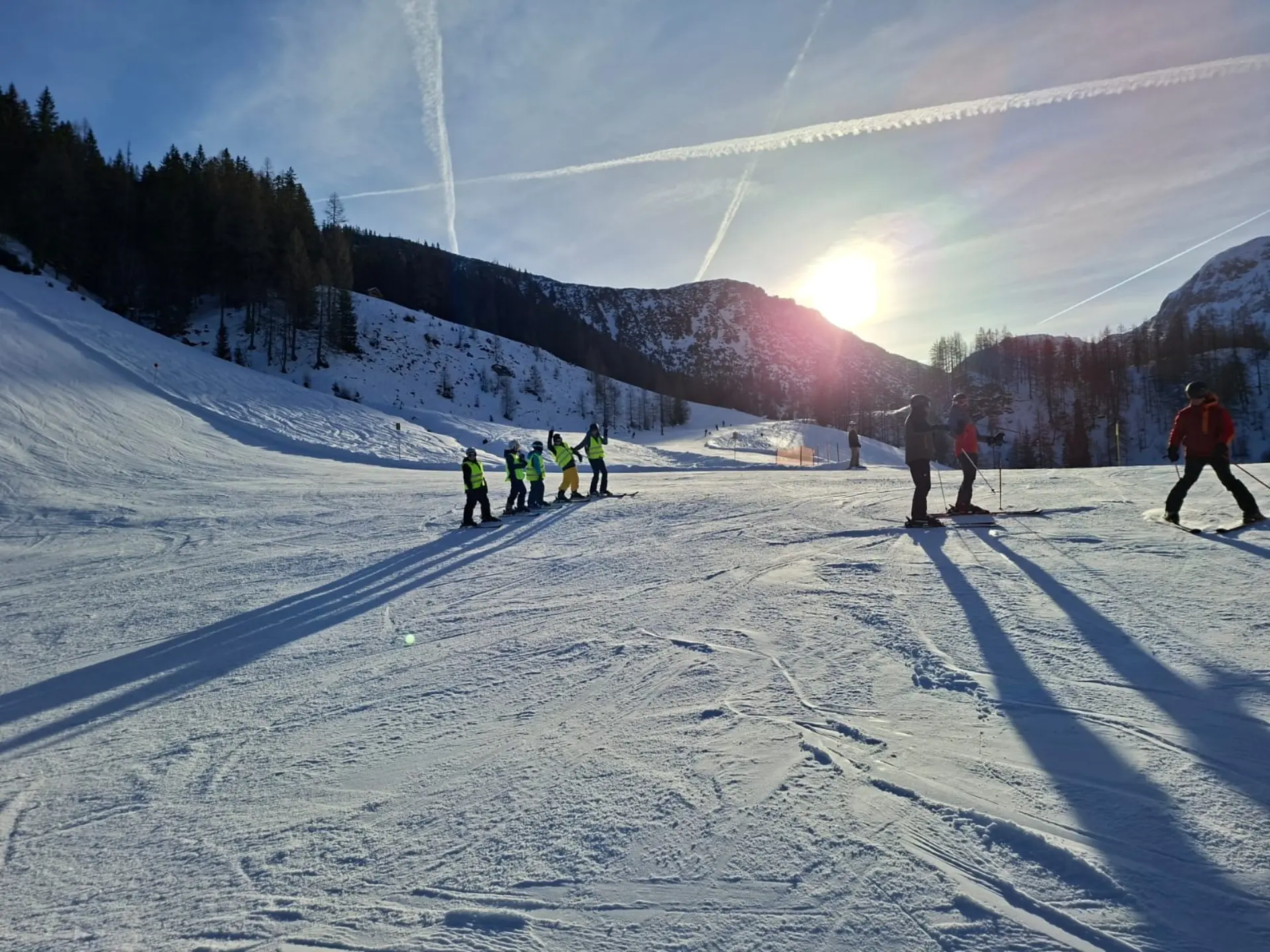 Eine winterliche Landschaft mit Bergen im Hintergrund ist zu sehen. Es liegt viel Schnee.